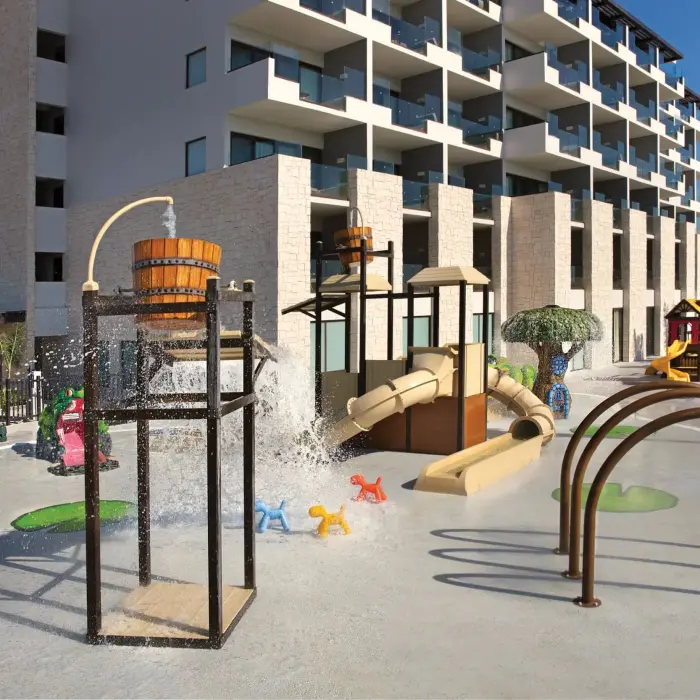 Outdoor Explorer’s Club play zone with splash bucket, slides, and colorful animal-themed spray features.