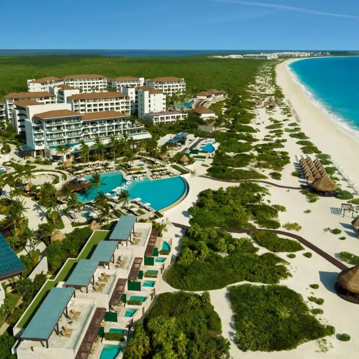 Dreams Playa Mujeres Resort aerial showing pools, oceanfront, and tropical landscape from above.