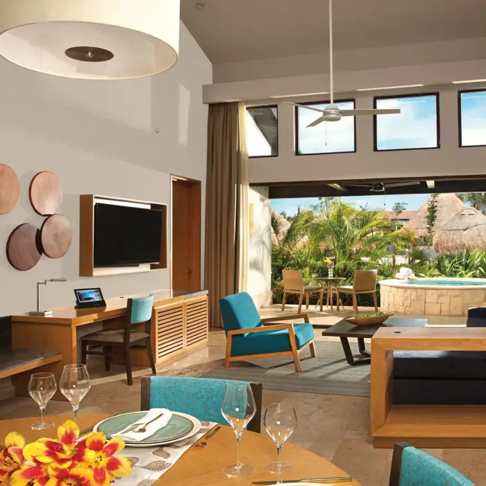 Open-concept villa living and dining area with modern décor and terrace access at Dreams Resort.