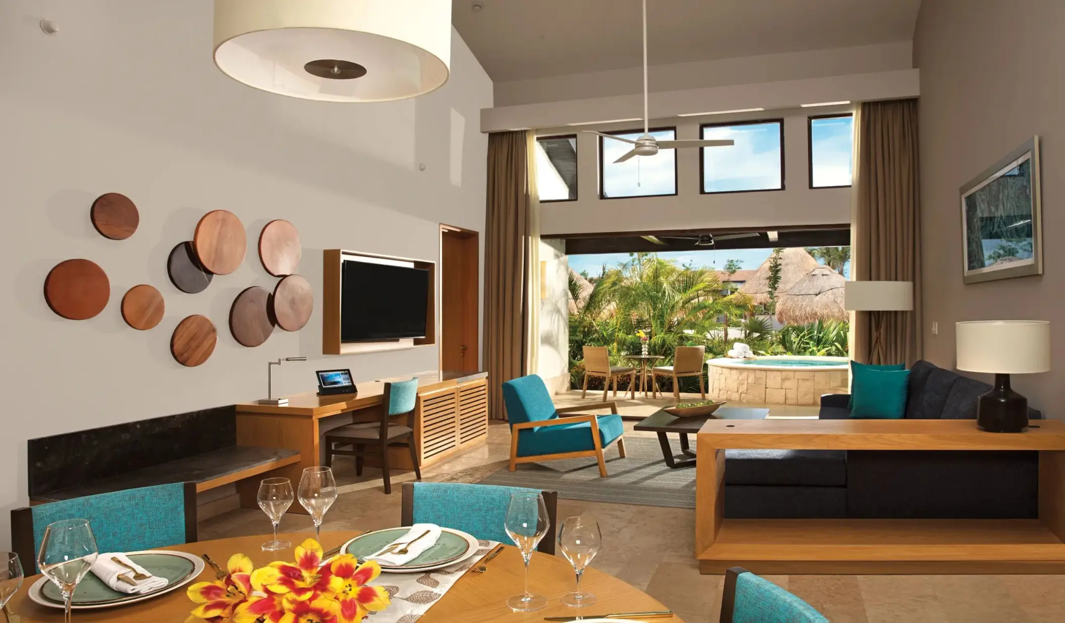 Open-concept villa living and dining area with modern décor and terrace access at Dreams Resort.