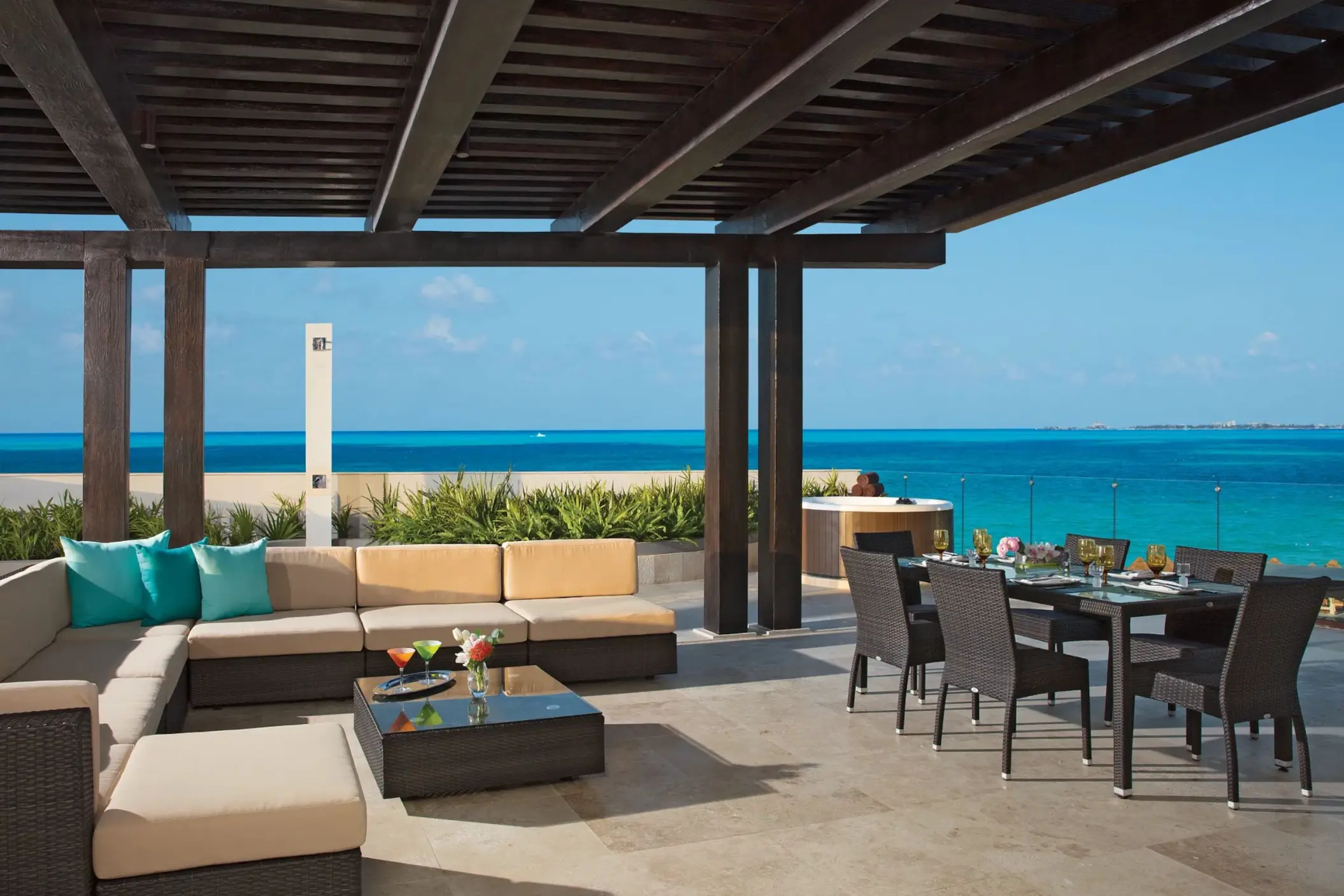 Expansive terrace with ocean views, lounge seating, and dining area in family presidential suite.