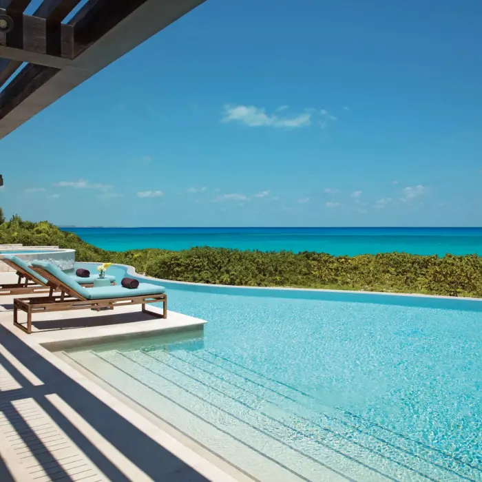 Presidential Suite outdoor infinity pool with lounge chairs and ocean view at Dreams Playa Mujeres.