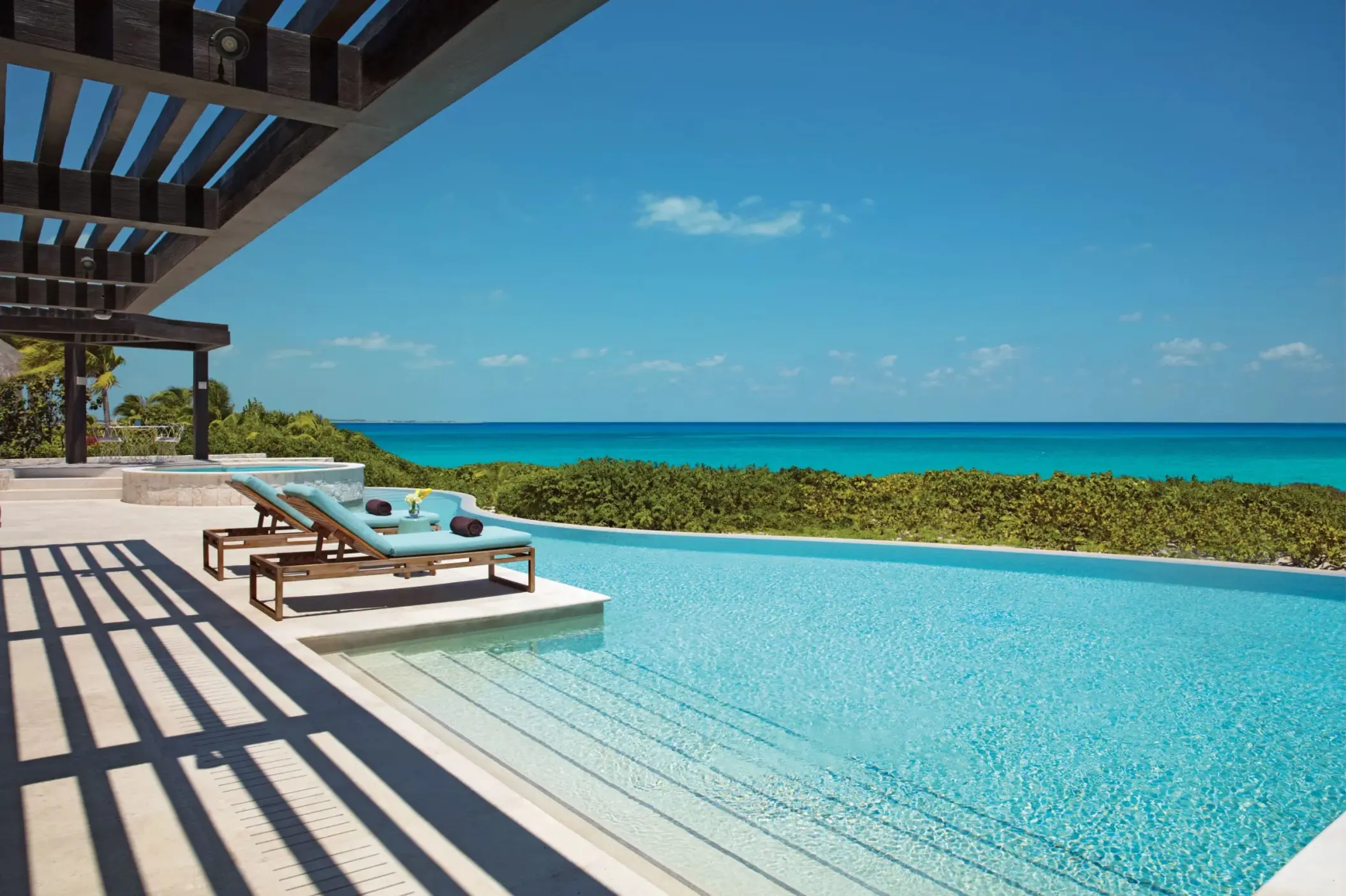 Presidential Suite outdoor infinity pool with lounge chairs and ocean view at Dreams Playa Mujeres.