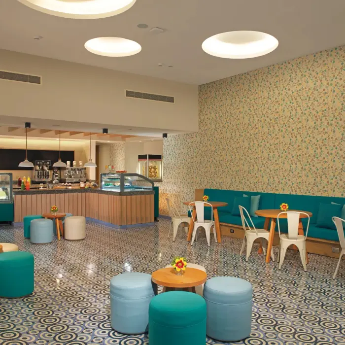 Dolce dessert café with playful patterned flooring, pastel seating, and a variety of sweet treats and gelato.