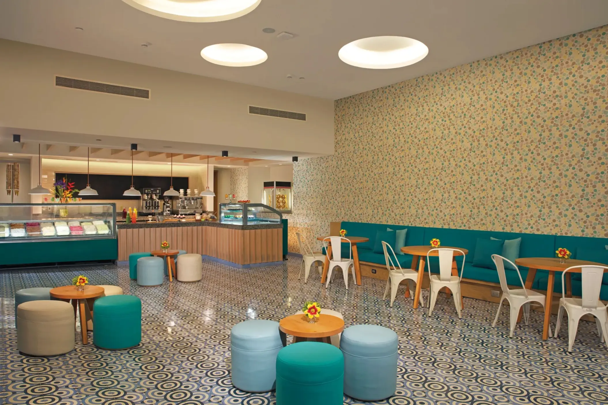Dolce dessert café with playful patterned flooring, pastel seating, and a variety of sweet treats and gelato.