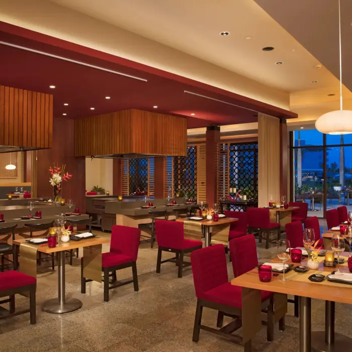 Fusion restaurant offers contemporary Asian dining with bold décor, teppanyaki tables, and red seating.