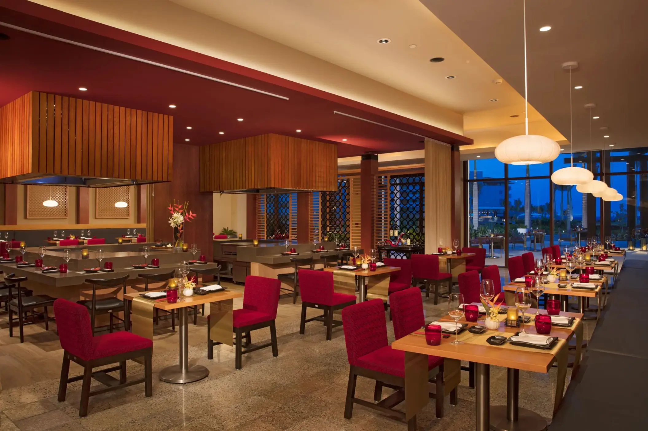 Fusion restaurant offers contemporary Asian dining with bold décor, teppanyaki tables, and red seating.