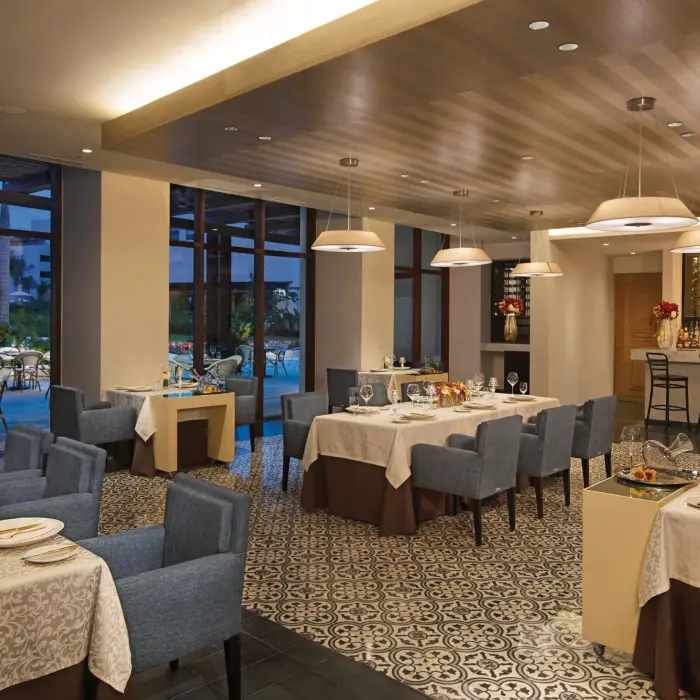 L’Etoile restaurant showcases elegant fine dining with blue chairs, patterned floors, and warm ambient lighting.