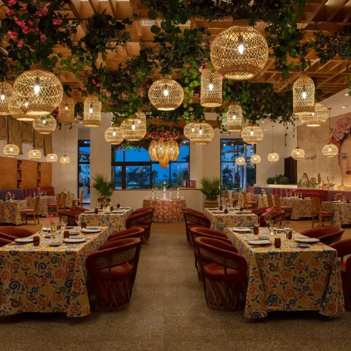 Tres Colores restaurant boasts vibrant Mexican decor, hanging lanterns, and colorful mural-inspired artwork.