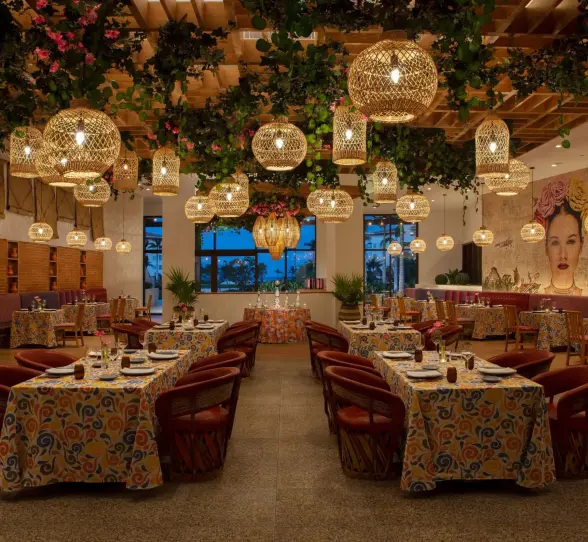 Tres Colores restaurant boasts vibrant Mexican decor, hanging lanterns, and colorful mural-inspired artwork.