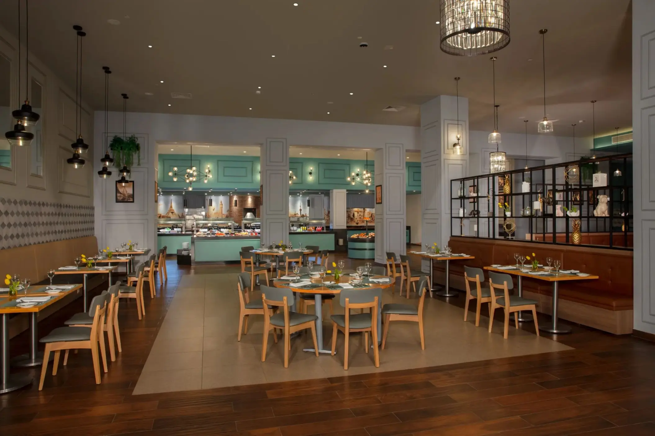 Elegant indoor dining area at World Café with turquoise buffet stations and modern hanging lights.