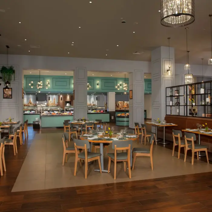 Elegant indoor dining area at World Café with turquoise buffet stations and modern hanging lights.