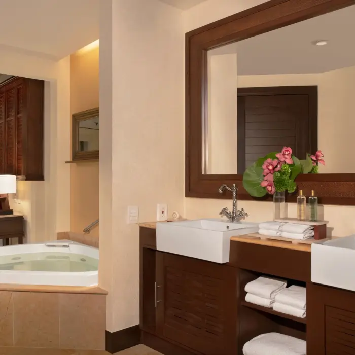 Honeymoon Suite bathroom with Jacuzzi and twin sinks in an intimate, softly lit space.