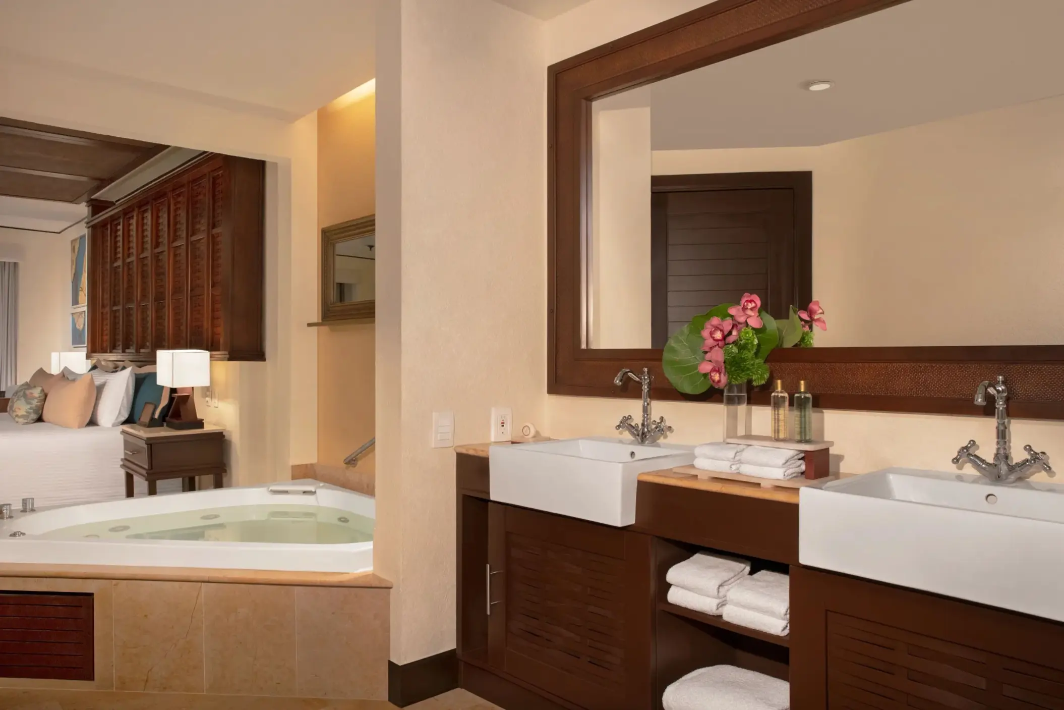Honeymoon Suite bathroom with Jacuzzi and twin sinks in an intimate, softly lit space.