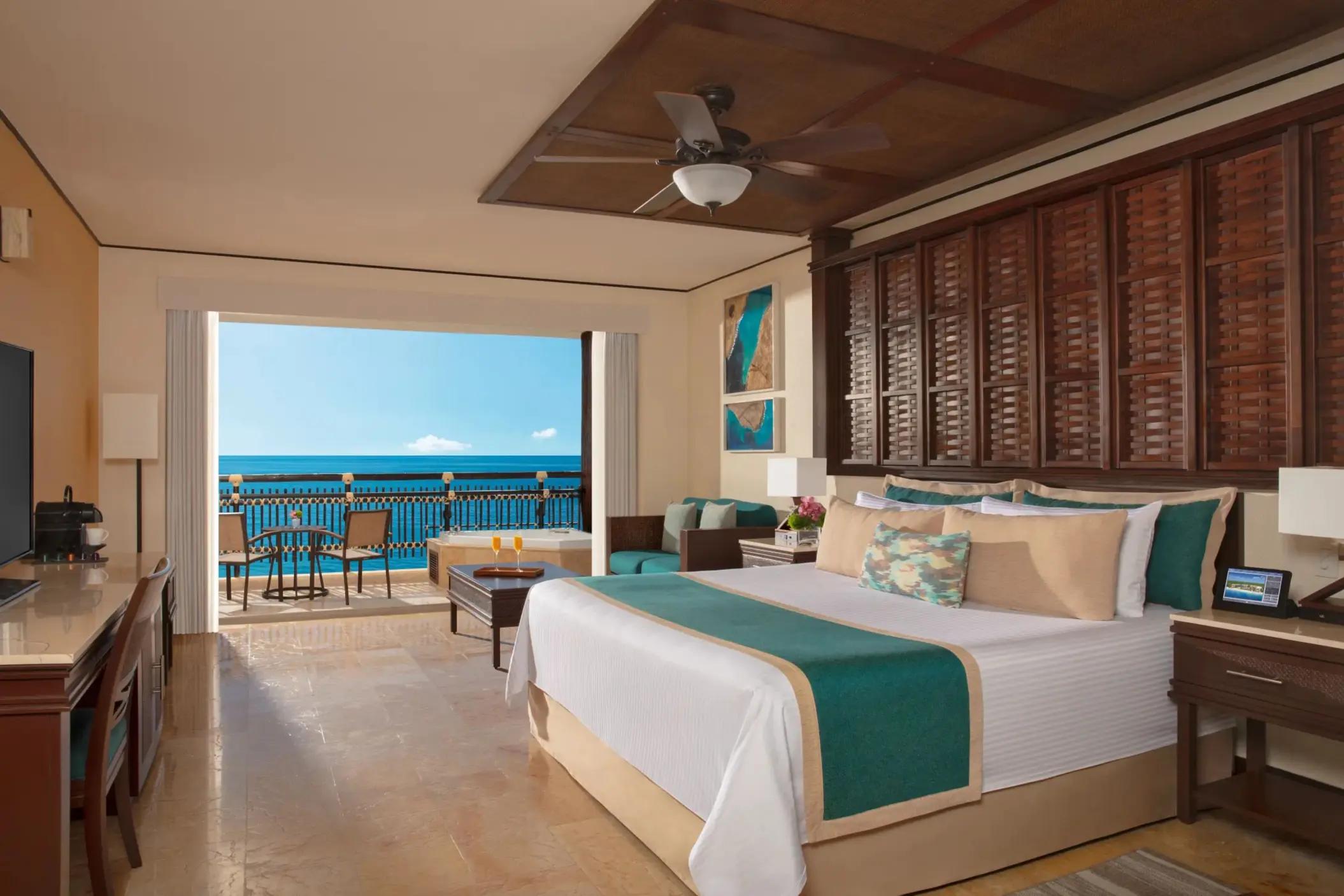 Ocean-facing Honeymoon Suite with king bed, seating area, and bright balcony view.