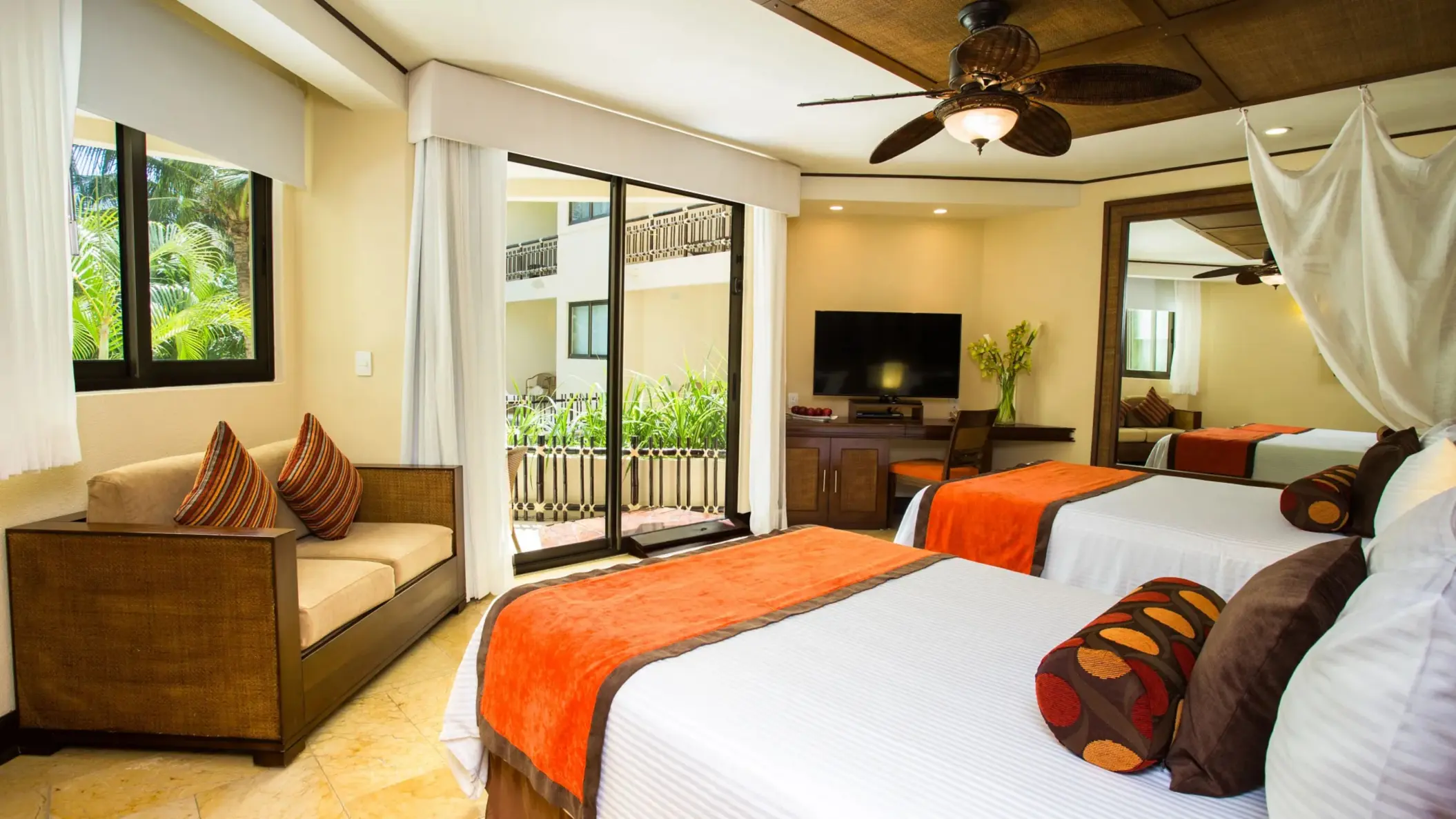 View from accessible deluxe room featuring double beds, modern seating area, and private balcony.