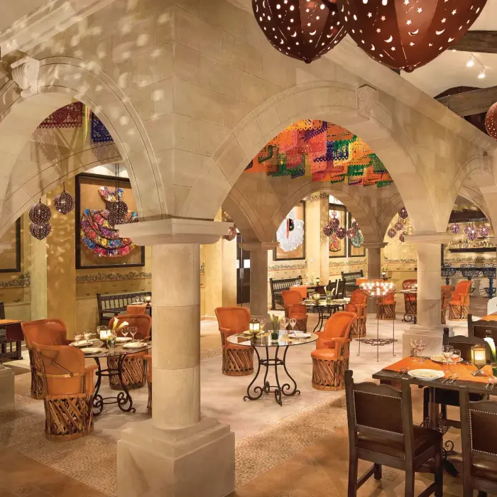 Traditional Mexican decor at El Patio in Dreams Riviera Cancun with arches, papel picado, and rustic charm.