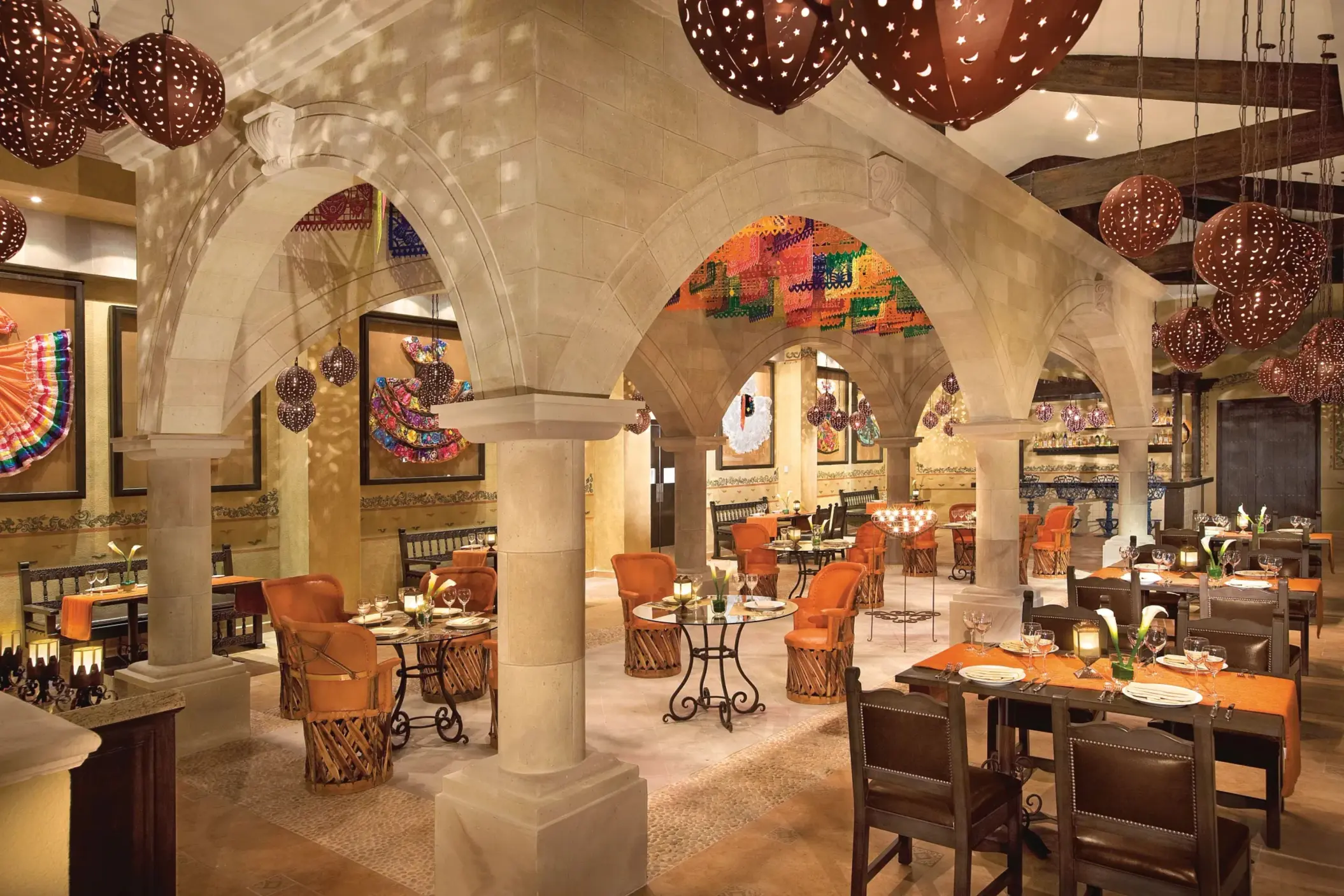 Traditional Mexican decor at El Patio in Dreams Riviera Cancun with arches, papel picado, and rustic charm.