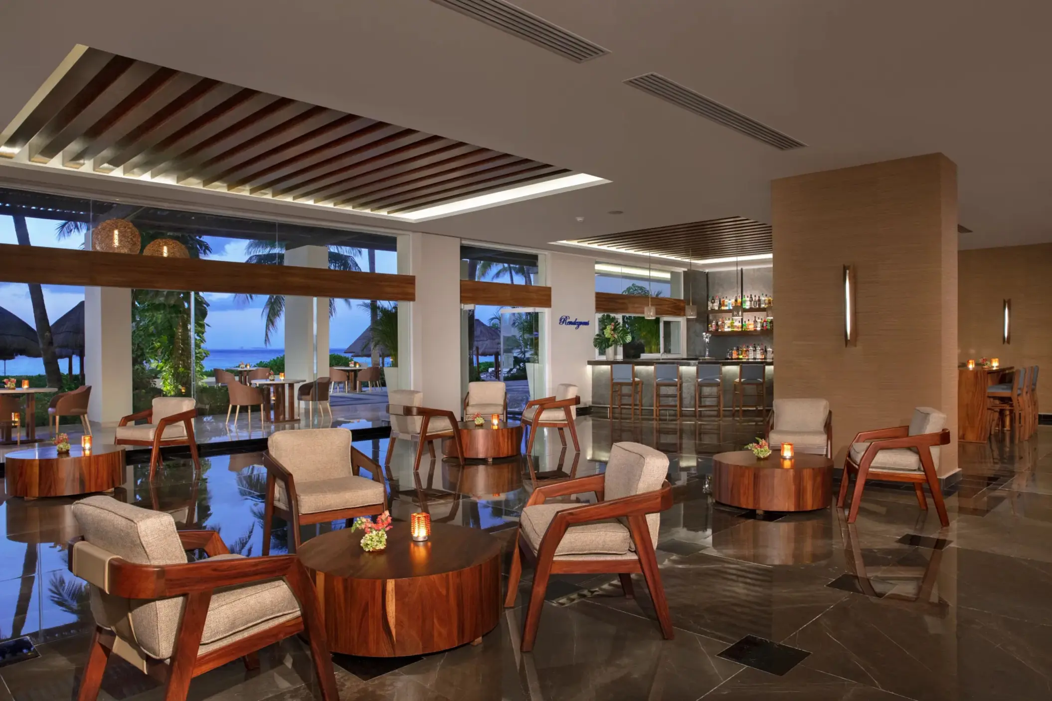 Lounge bar with modern seating and sea views through floor-to-ceiling windows.