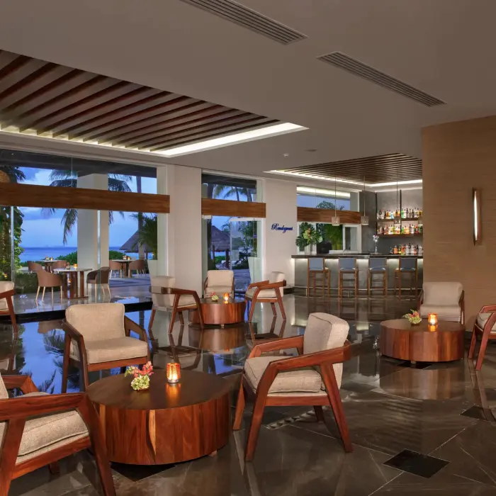 Lounge bar with modern seating and sea views through floor-to-ceiling windows.
