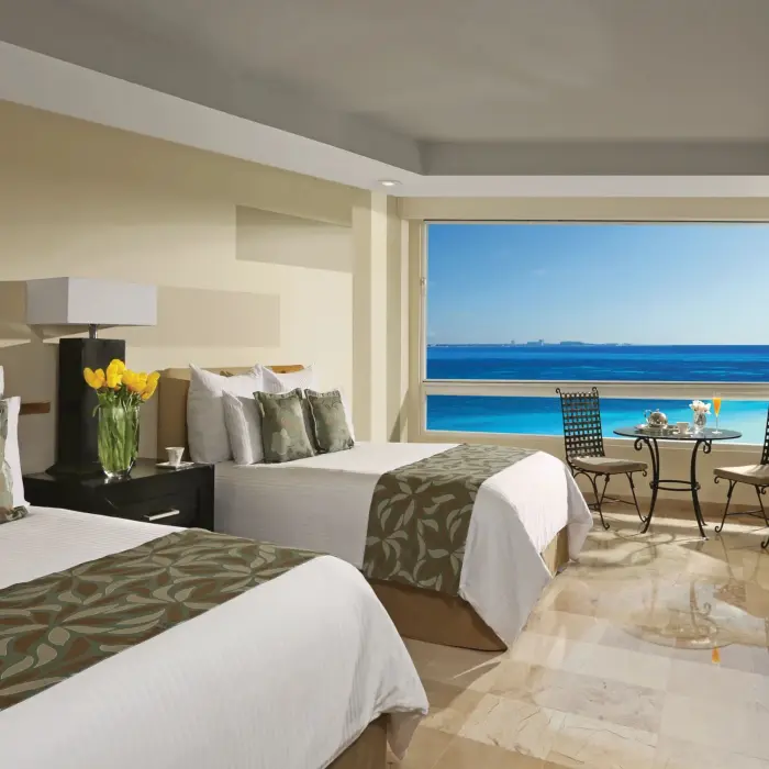 Double oceanfront room with two beds, tropical decor, and breathtaking Caribbean views.