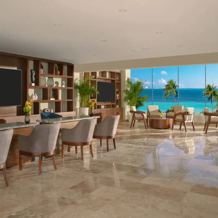 Elegant resort lounge with ocean views, comfortable seating, and warm wood accents in a relaxed setting.