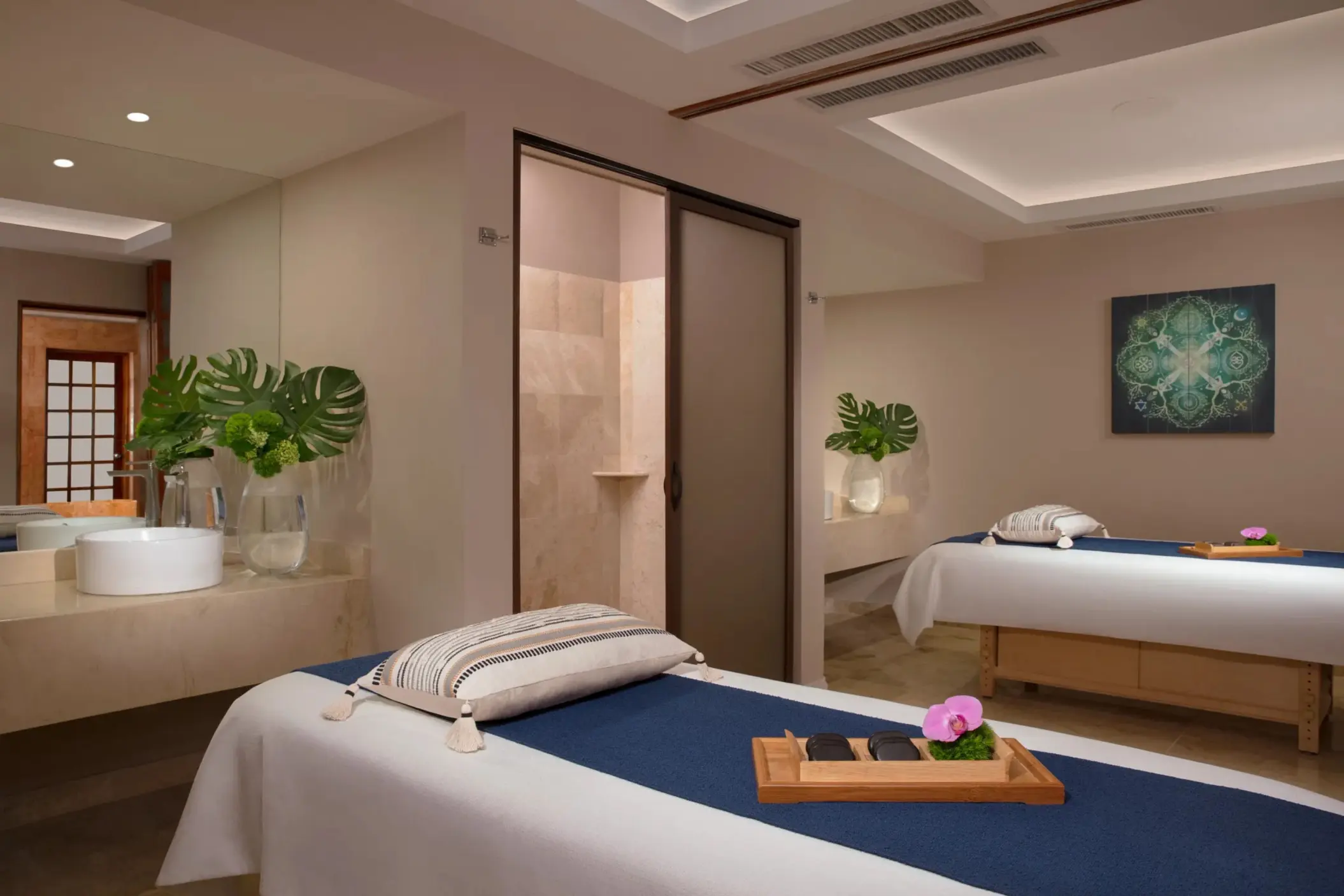 Peaceful spa cabin with twin massage tables, soft lighting, and natural décor elements.