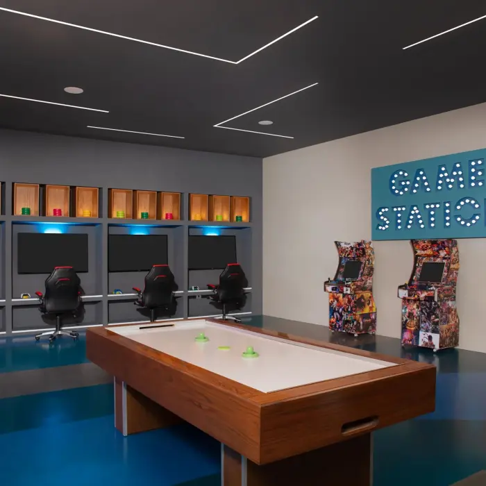 Game room featuring arcade machines, air hockey, and gaming stations with LED lighting and modern decor.
