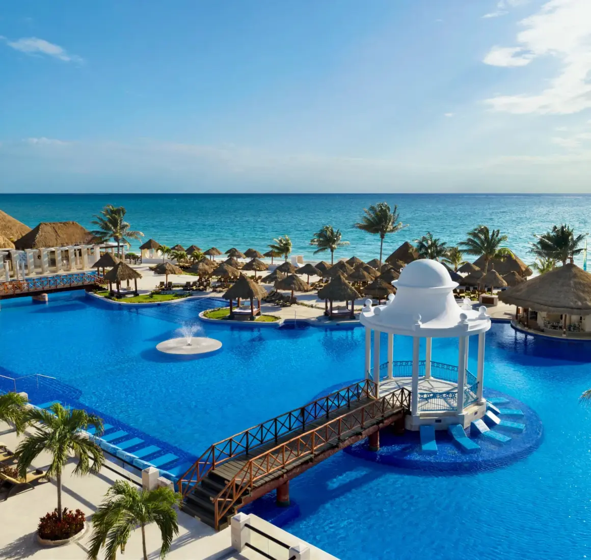 Sparkling main pool surrounded by palm trees and luxury loungers at Dreams Sapphire Resort & Spa.
