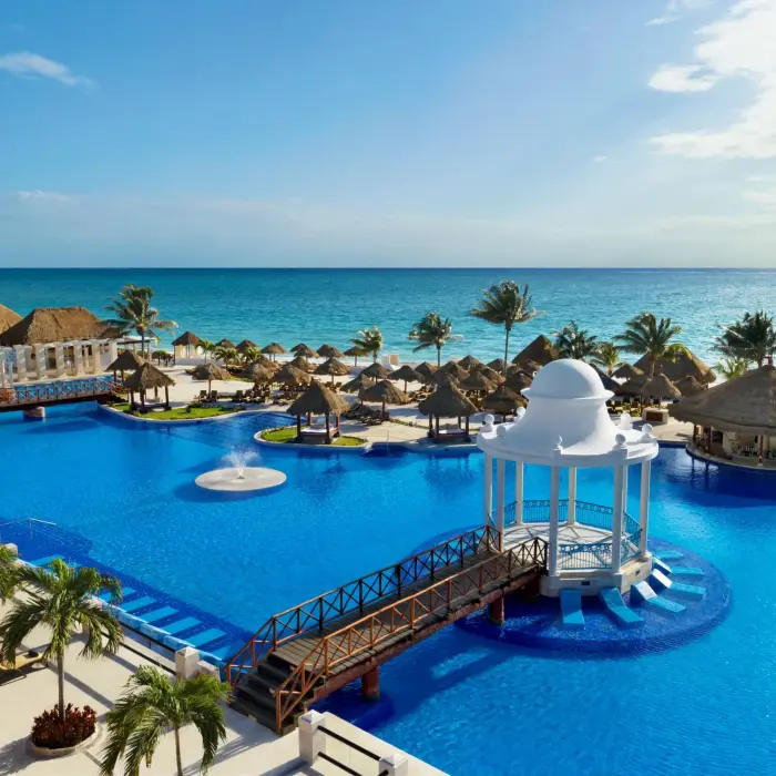 Sparkling main pool surrounded by palm trees and luxury loungers at Dreams Sapphire Resort & Spa.