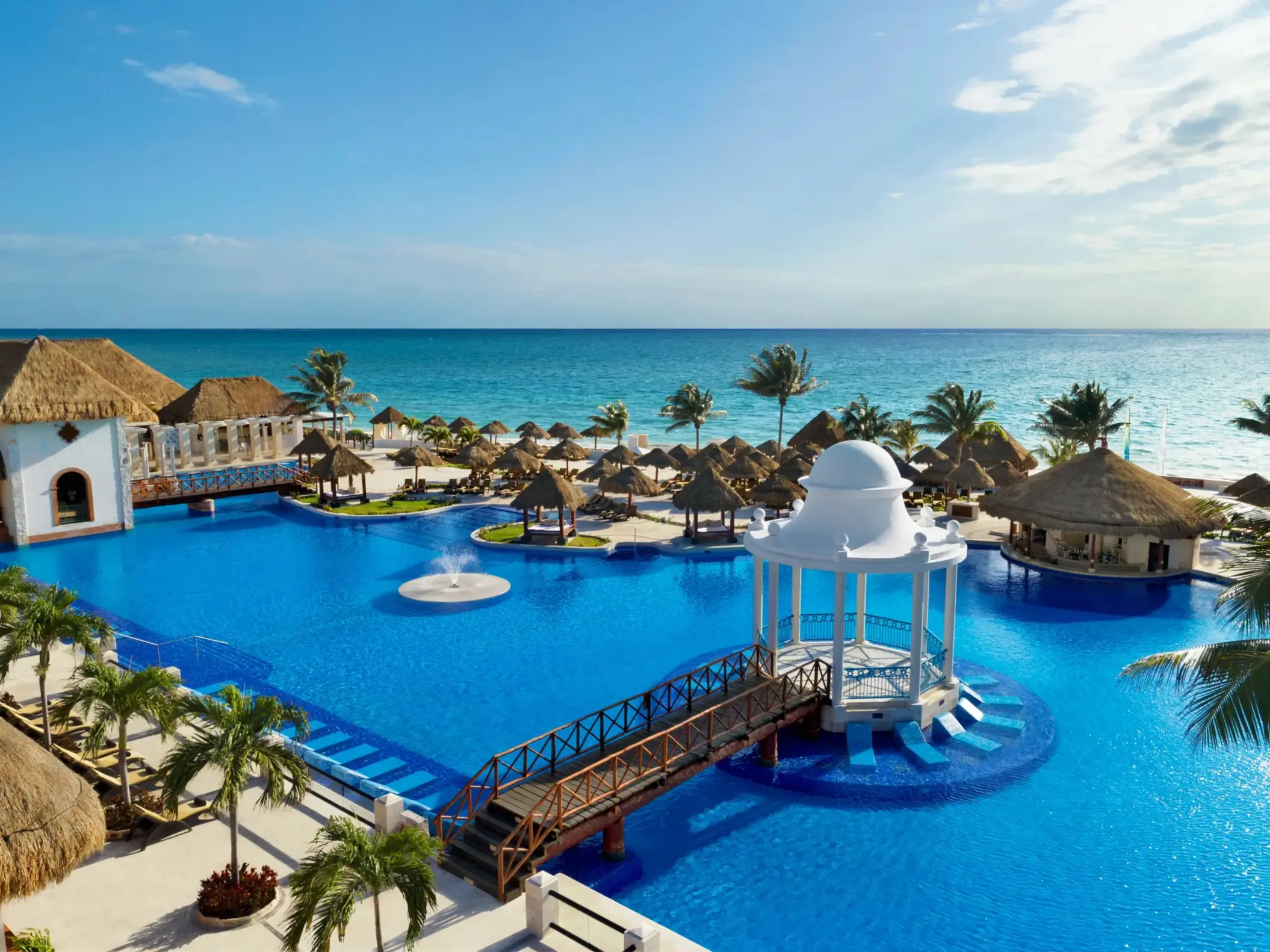 Sparkling main pool surrounded by palm trees and luxury loungers at Dreams Sapphire Resort & Spa.