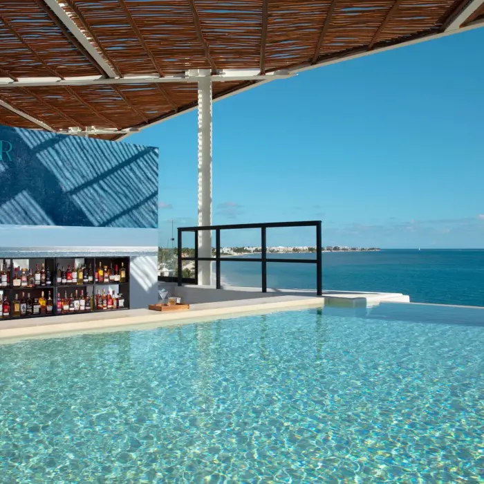 Rooftop SkyBar with ocean views and craft cocktails at Dreams Sapphire Resort & Spa, the perfect sunset hangout.