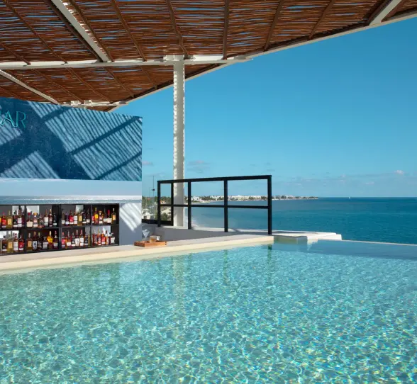 Rooftop SkyBar with ocean views and craft cocktails at Dreams Sapphire Resort & Spa, the perfect sunset hangout.