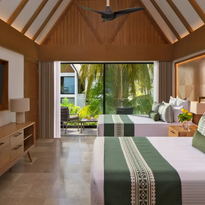 Charming private villa room with double beds, ideal for family getaways.