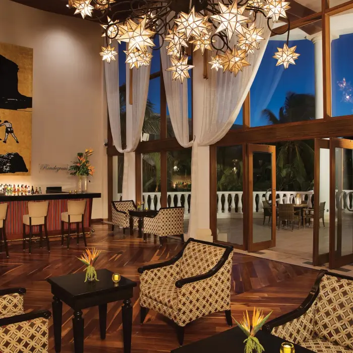 Chic hotel bar with star-shaped chandeliers, modern art, and an open-air terrace for evening cocktails.