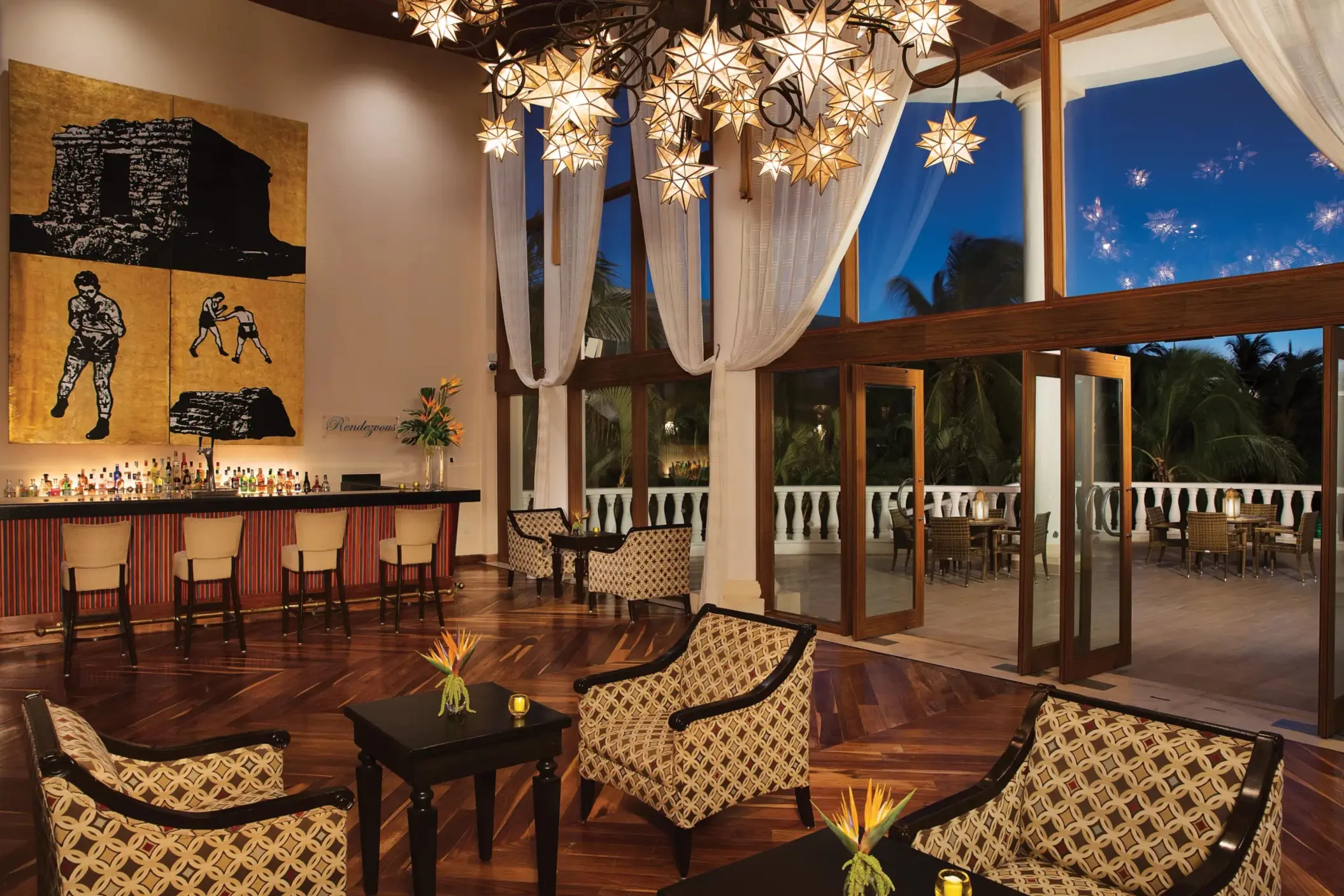 Chic hotel bar with star-shaped chandeliers, modern art, and an open-air terrace for evening cocktails.