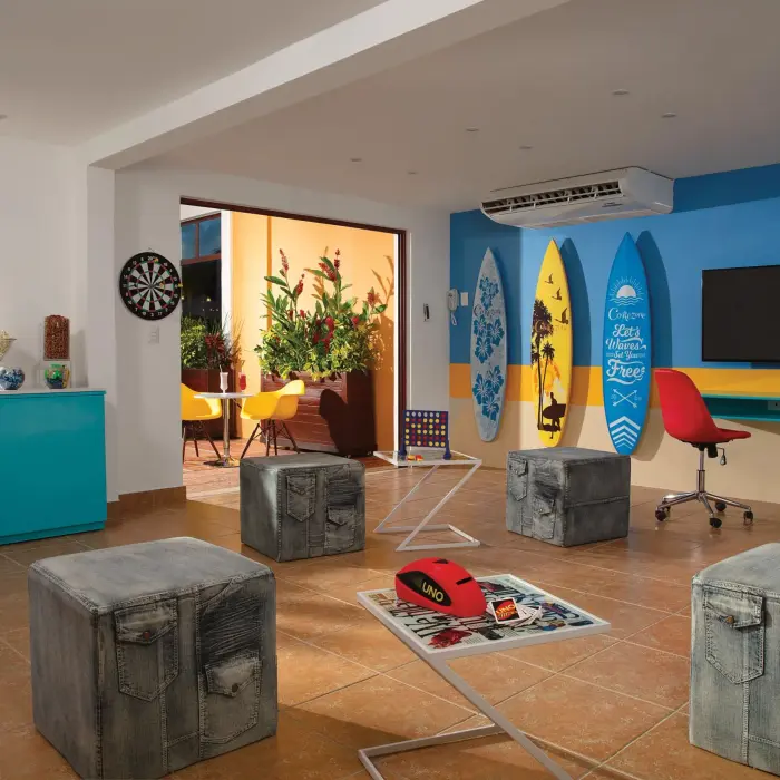 Colorful Core Zone Teens Club with surfboard decor, gaming stations, and lounge seating at Dreams Tulum.