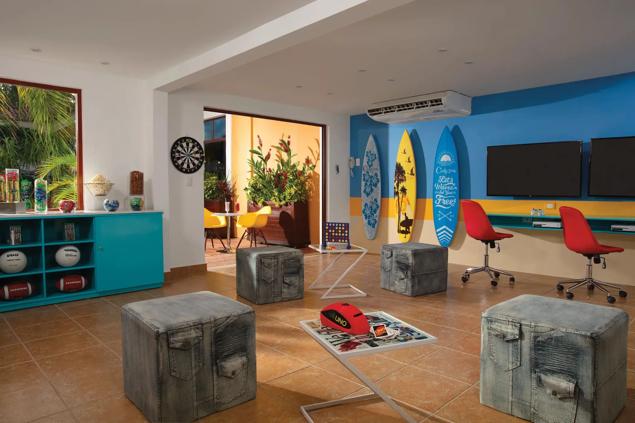 Colorful Core Zone Teens Club with surfboard decor, gaming stations, and lounge seating at Dreams Tulum.