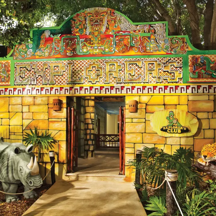Vibrant Mayan-themed entrance to Dreams Tulum’s Explorer’s Club for kids, with stone walls and playful animal statues.