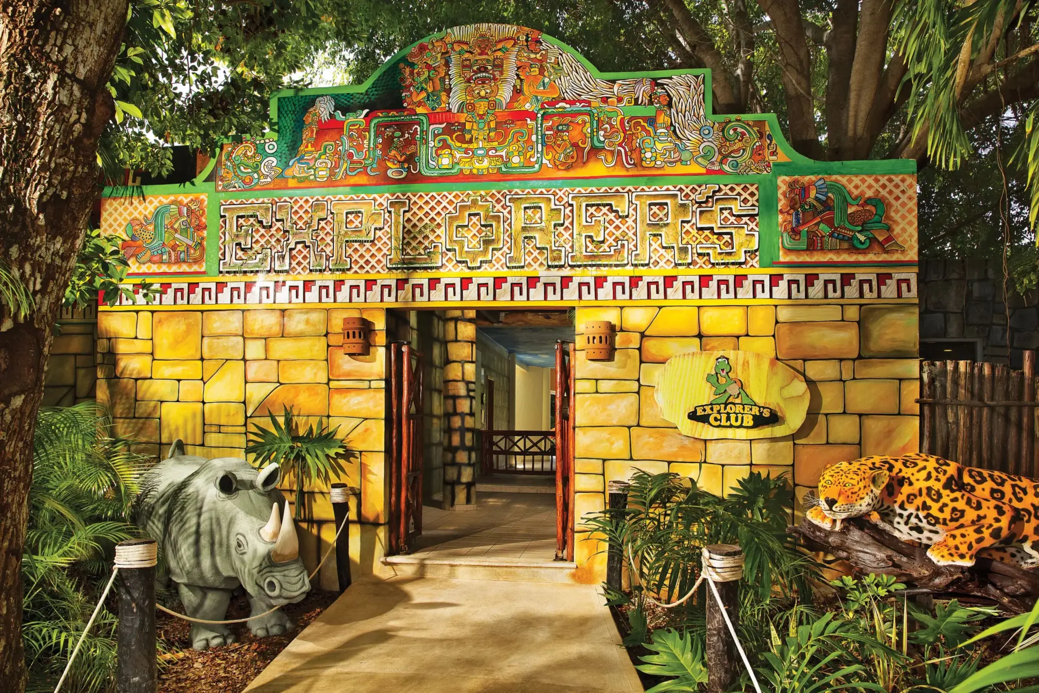 Vibrant Mayan-themed entrance to Dreams Tulum’s Explorer’s Club for kids, with stone walls and playful animal statues.