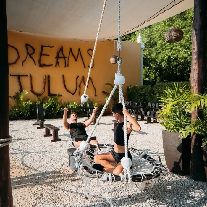 Outdoor fitness area at Dreams Tulum with natural wooden decor, rope equipment, and open-air training zones.