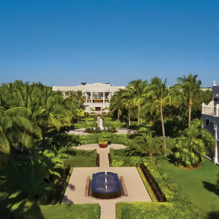 Panoramic garden view at Dreams Tulum with symmetrical walkways, water features, and tropical landscaping.