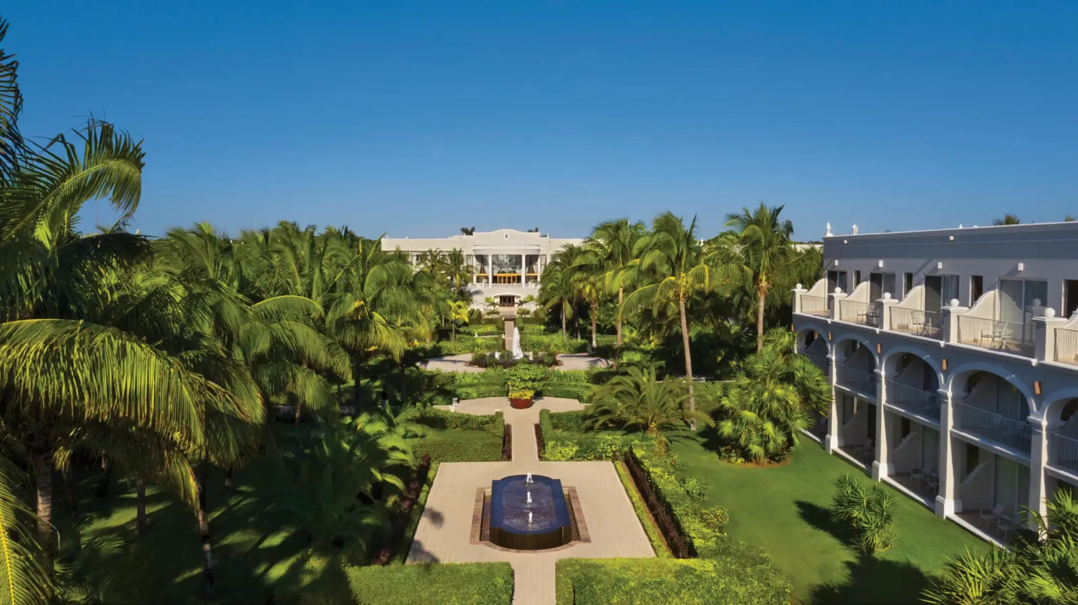 Panoramic garden view at Dreams Tulum with symmetrical walkways, water features, and tropical landscaping.