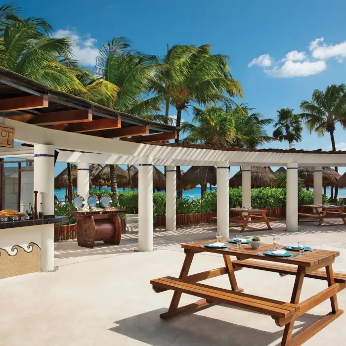 Outdoor Barefoot Grill with picnic tables, tropical views, and buffet-style service near the beach.