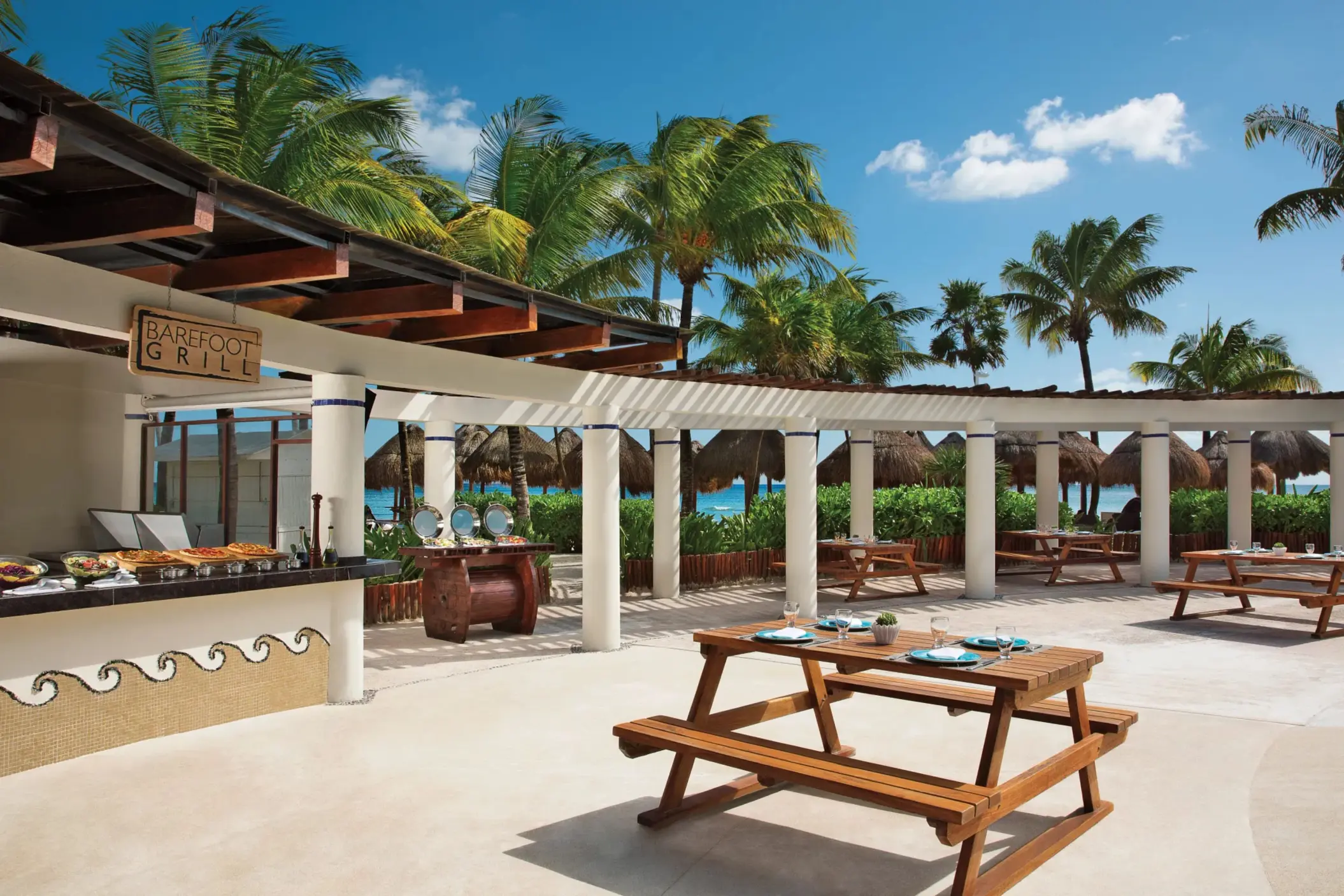 Outdoor Barefoot Grill with picnic tables, tropical views, and buffet-style service near the beach.