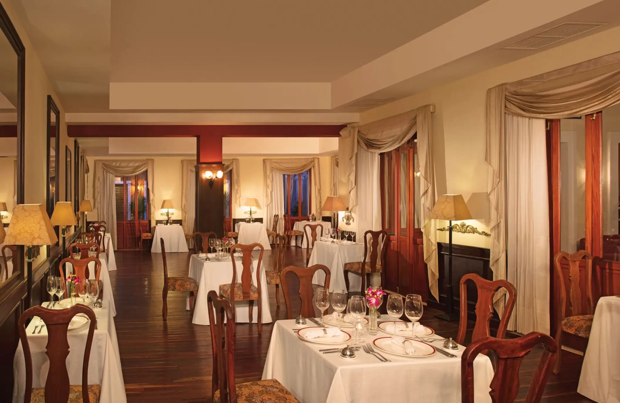 Fine dining at Bordeaux restaurant with white tablecloths, elegant wooden chairs, and warm lighting.