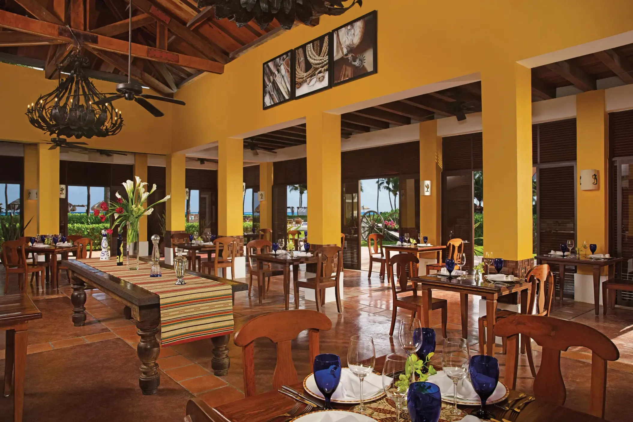 Mexican restaurant with wooden furnishings, rustic chandeliers, and open-air views of the garden.