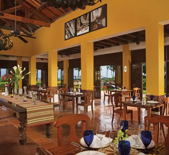Mexican restaurant with wooden furnishings, rustic chandeliers, and open-air views of the garden.
