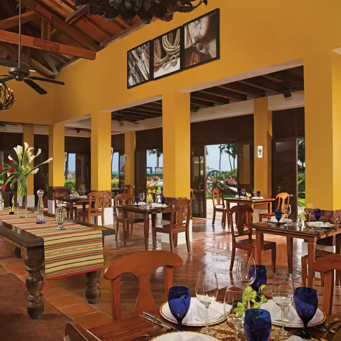 Mexican restaurant with wooden furnishings, rustic chandeliers, and open-air views of the garden.