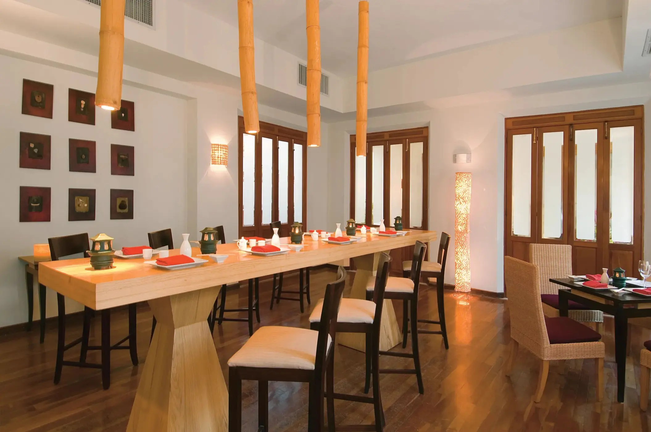 Contemporary sushi bar with minimalist wooden decor and hanging bamboo lights.